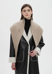 Detail of wool knit shawl paired with a black faux leather shearling-lined winter coat