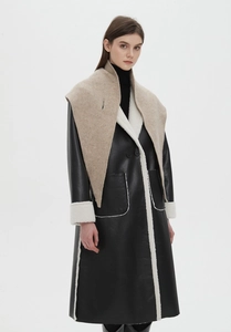 Close-up of oatmeal knit shawl styled over a black faux fur shearling leather coat