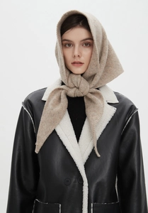 Close-up of oatmeal wool knitted hooded scarf texture and winter layering detail