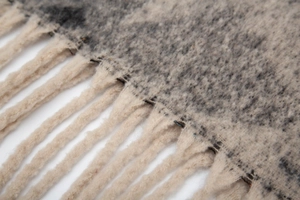 Macro view of thick jacquard star pattern scarf with textured fringe tassels