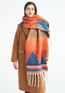 Detail of thick knit scarf with geometric color blocks and long white tassels