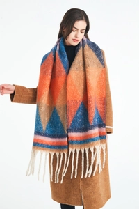 Close-up of thick geometric knit scarf featuring orange triangles and white fringe detail