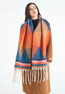Detail of colorful geometric pattern scarf with thick tassels on wool coat