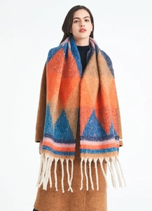 Detailed view of women's thick scarf featuring colorful geometric patterns and white fringe
