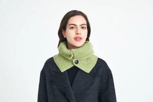 Close-up of green knitted neck warmer with ribbed texture and single button closure
