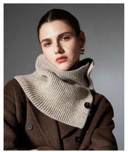 Detail of beige ribbed wool knit neck warmer featuring a dark button accent and texture
