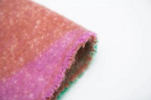Macro detail of brushed mohair-like fringe scarf with colorful gradient textile texture