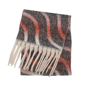 Détails macro de la maille à motif vagues et des longs pompons crème sur l'écharpe