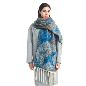 Chunky knit jacquard star scarf with fringe tassels shown on a grey winter coat