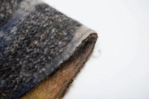 Détail du tissu en fil bouclé gris bleu jaune avec texture épaisse style mohair