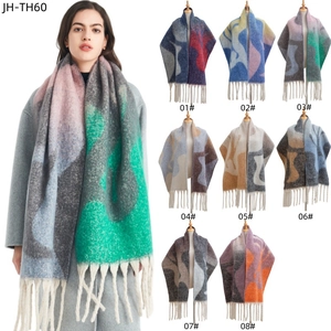 Détail de l'écharpe en maille jacquard géométrique montrant les franges et les coloris