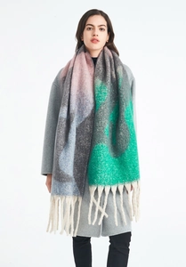 Gros plan détaillé de l'écharpe en maille jacquard colorée avec de longues franges crème