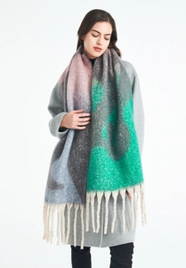 Gros plan d'une écharpe en tricot épais avec des franges et des blocs de couleurs