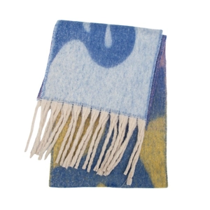 Détail d'une écharpe en maille jacquard avec motifs géométriques et longues franges