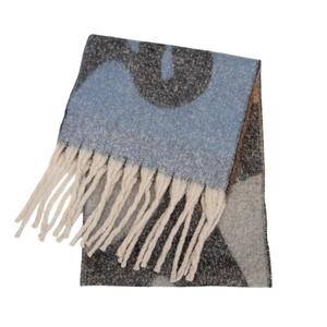Détail de l'écharpe en maille jacquard bleu et gris avec texture et larges pompons écrus