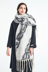Close-up of thick knit shawl scarf with chain pattern texture and elegant long fringe