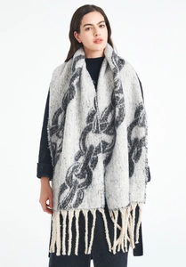 Close-up of thick winter shawl featuring grey chain pattern and long fringe details
