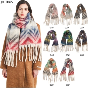 Detail view of woven zigzag mountain patterns and long tassels on soft winter scarves