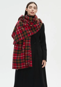 Detailed close-up of thick red tartan scarf texture with overlock stitched edge