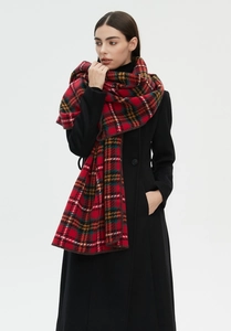 Detailed view of red Scottish tartan scarf with fine lock-stitched edges on black coat