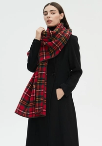 Close-up of classic red and green plaid scarf styled with a black autumn wool coat