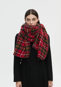 Detailed view of red tartan plaid scarf with reinforced edge stitching on black coat