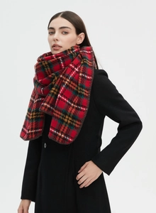 Detailed close-up of a classic red plaid wool scarf featuring fine overlocked stitching edges