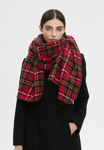 Detailed texture of red plaid scarf showing high-quality wool fabric and overlocked edges