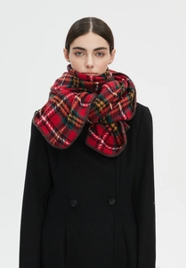 Close-up of red and green tartan scarf paired with a classic black winter wool coat