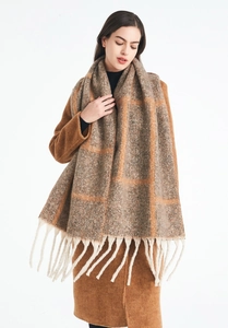 Close-up of thick plaid shawl scarf with orange and brown checks and long white tassels
