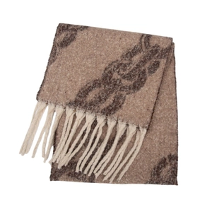 Macro detail of thick knit shawl with brown chain pattern and cream fringe tassels