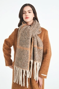 Detail shot of winter plaid scarf with fringe paired with a warm caramel wool coat