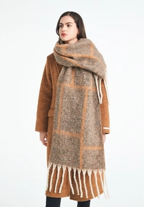 Detail of winter plaid scarf featuring thick tassels and brown jacquard pattern