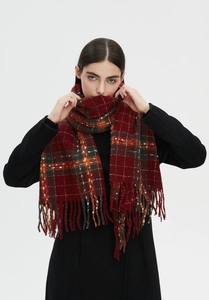 Dettaglio della sciarpa a quadri rossi e verdi con spesse frange e classico motivo tartan