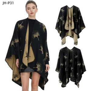 Detail of black knit shawl with golden ginkgo leaf pattern and reversible split design