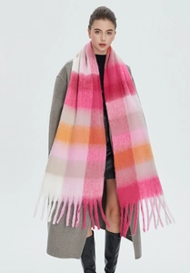 Close-up of fuzzy mohair texture on a pink and orange plaid winter scarf with tassels