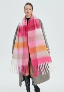 Detail of colorful rainbow plaid scarf with soft thick texture and long fringe tassels