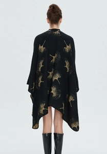 Detailansicht eines schwarzen Strickschals mit goldenem Ginkgoblatt-Muster