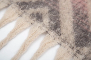 Close-up of textured boucle yarn fringe and mountain pattern jacquard on winter scarf