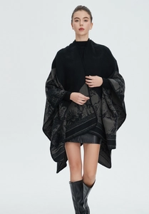 Detaillierte Strickstruktur und Jacquardmuster auf schwarzem Damen-Poncho-Schal