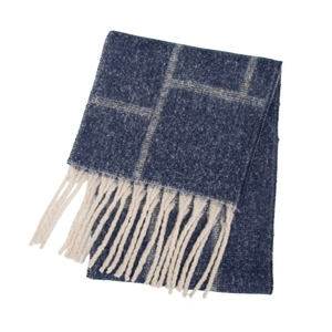 Detail of navy blue plaid scarf with thick knit texture and long cream fringe tassels