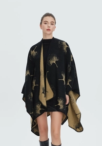 Detailansicht goldener Ginkgoblattmuster auf einem schwarzen Strickponcho mit Schlitz