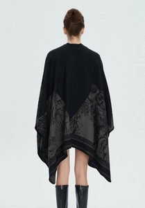 Detail eines gestrickten Damen-Schals mit grauem Jacquard-Muster auf schwarzem Stoff