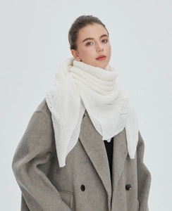 Detail of white hollowed-out knit shawl featuring intricate floral lace patterns for women