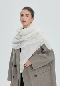 Detail of white hollow knit shawl showing intricate crochet patterns on grey coat