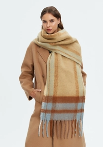 Close-up of thick checkered scarf with long tassels showing soft mohair-like texture