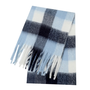 Close-up of thick blue and black plaid scarf with soft cashmere texture and fringe detail