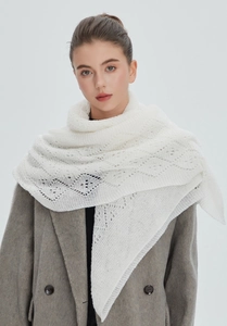Detail shot of the intricate hollow diamond knit pattern on white shawl scarf