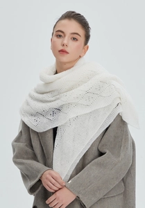 Detailed view of white hollow-out knit shawl texture on a grey wool coat