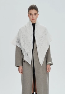 Close-up of white crochet hollow knit shawl featuring delicate geometric lace patterns